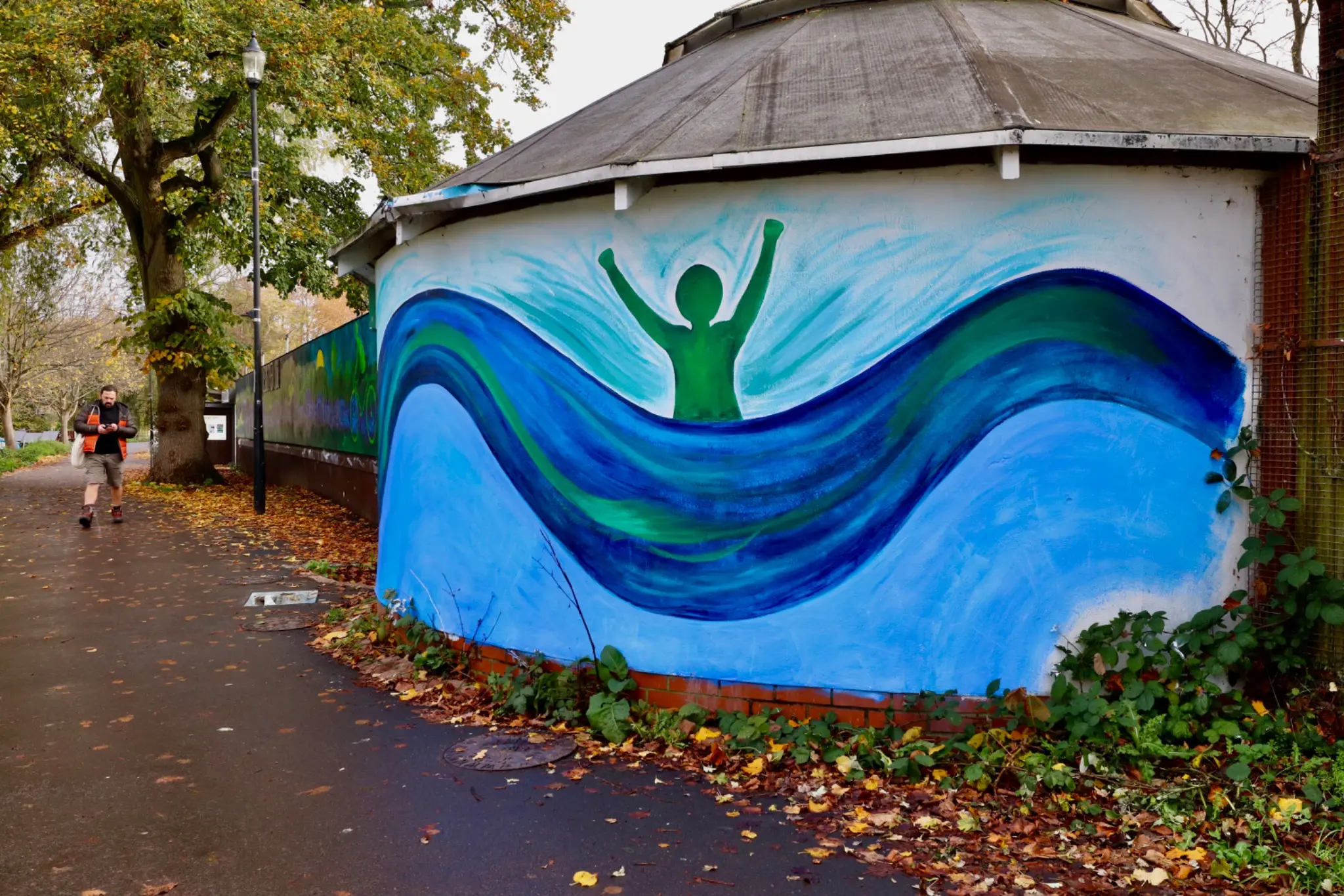 Curved end wall painted with a figure rising through blue and green waves