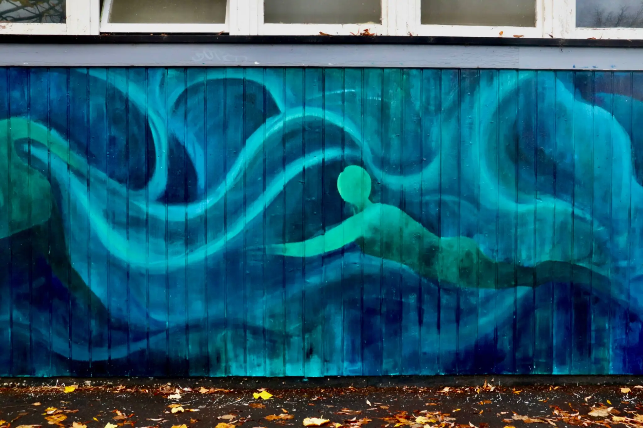 Close view of a green swimmer moving through layered blue currents